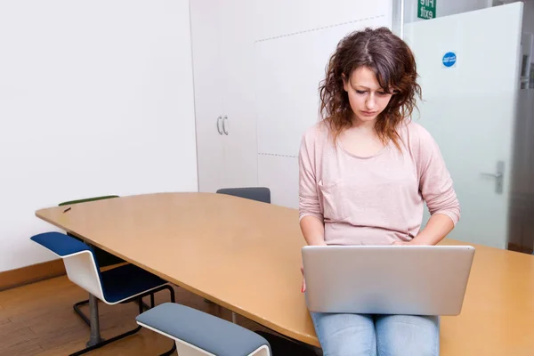 Junge Frau arbeitet am Laptop — Stockfoto