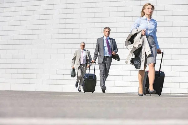 Businesspeople with luggage on street — Stock Photo, Image