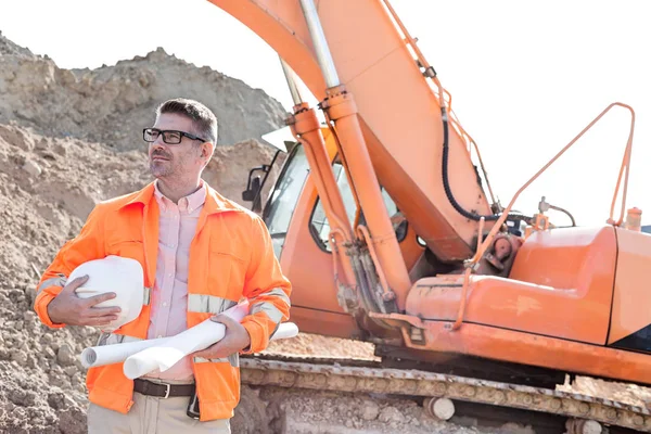 Kendine güvenen mimar holding hardhat ve planları — Stok fotoğraf