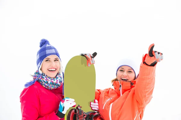 Smiling female friends with snowboard — Stock Photo, Image