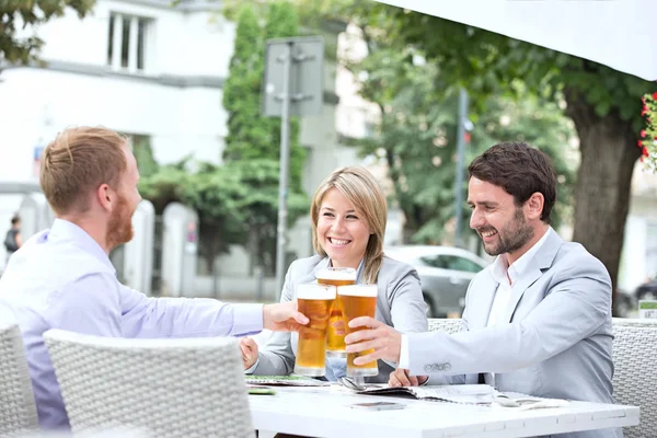 Des gens d'affaires grillent des verres à bière — Photo