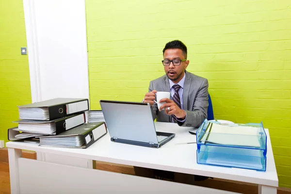 Empresário segurando caneca e trabalhando — Fotografia de Stock