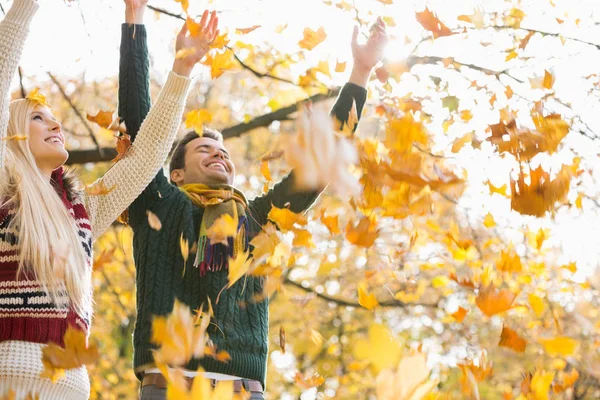 Couple enjoying falling autumn leaves — Stock Photo, Image