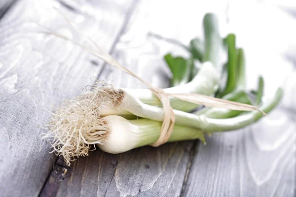 Leeks on wooden table — Stock Photo, Image