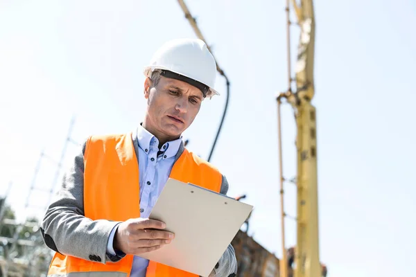 Supervisor escrevendo na área de transferência no canteiro de obras — Fotografia de Stock