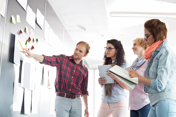 Empresario explicando documento a colegas femeninos — Foto de Stock