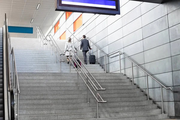 Businesspeople with luggage moving up stairs — Stock Photo, Image