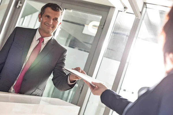 Empresário que recebe documento da recepcionista — Fotografia de Stock