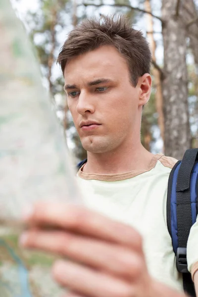 Hombre con mapa de lectura de mochila —  Fotos de Stock