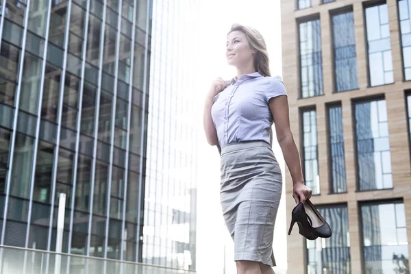 Mujer de negocios sosteniendo tacones altos —  Fotos de Stock