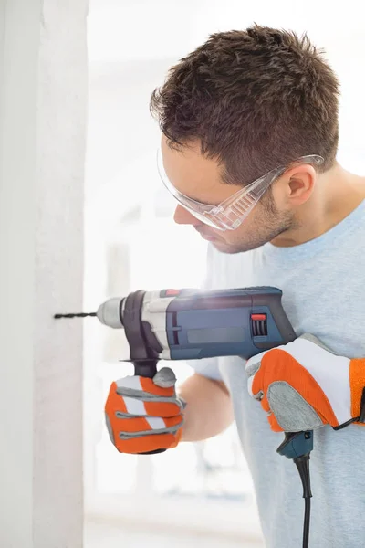 Man boren in de muur — Stockfoto