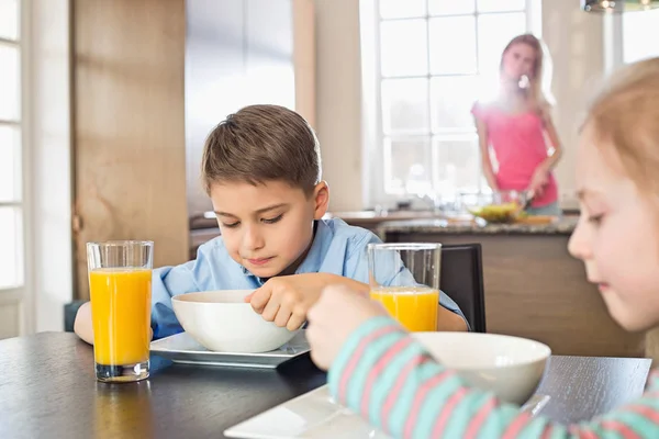 Syskon med frukost vid bord — Stockfoto