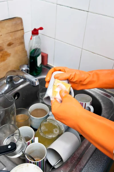 Женские руки в перчатках для мытья чашек — стоковое фото