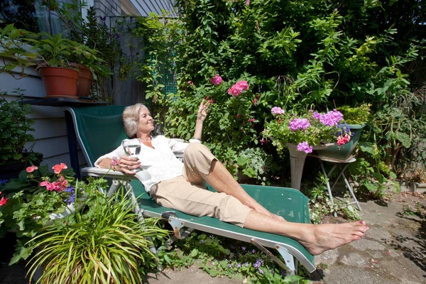 Femme âgée se détendre sur chaise longue — Photo