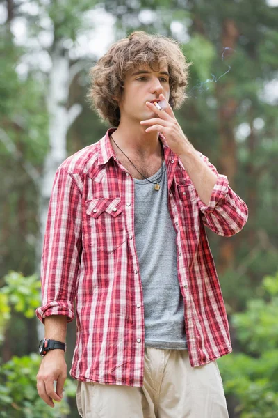 Man smoking in forest — Stock Photo, Image