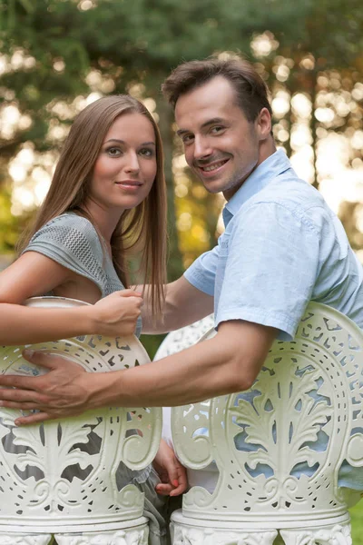 Couple sitting on chairs in park — Stock Photo, Image