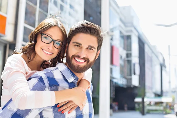 Man giving piggyback ride to woman — Stock Photo, Image