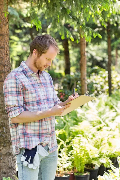 Male supervisor writing on clipboard — Stock Photo, Image