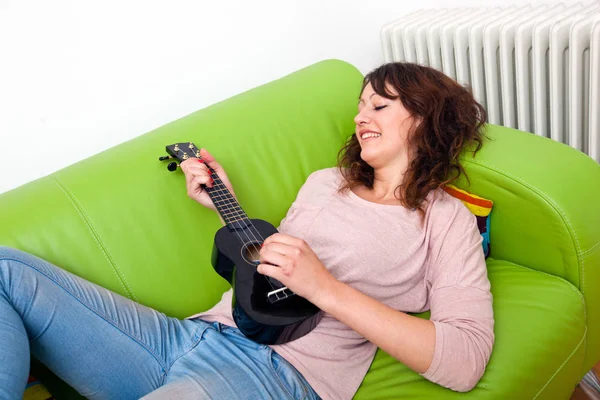 Молода жінка грає укулеле — стокове фото