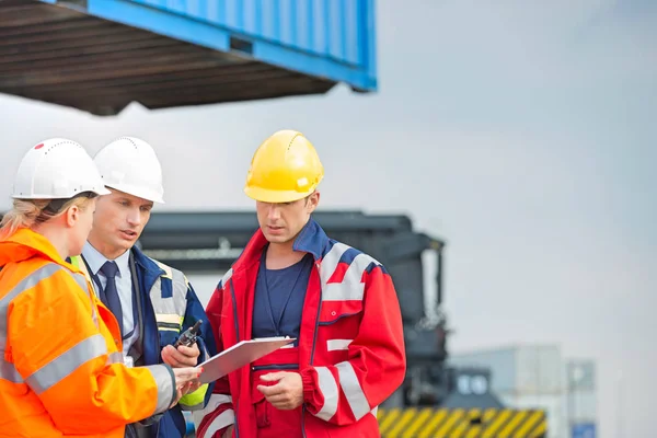 Workers discussing over clipboard — Stock Photo, Image