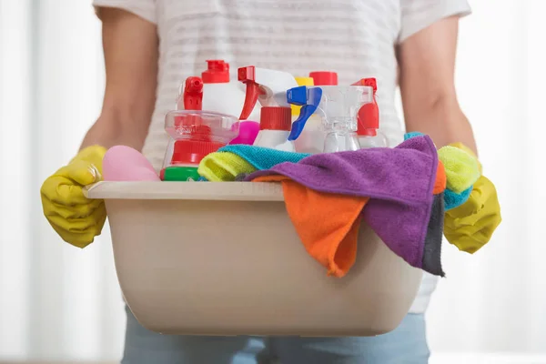 Woman carrying basket of cleaning supplies — Stock Photo, Image