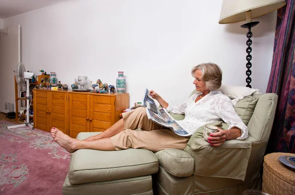 Seniorkvinne leser avis – stockfoto