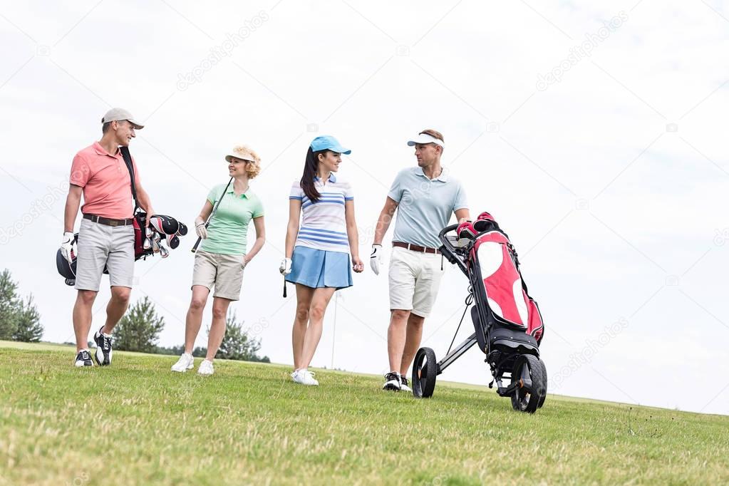 Friends walking at golf course — Stock Photo © londondeposit 138120730