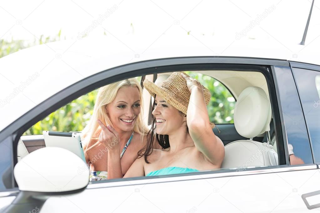 friends using digital tablet in car 