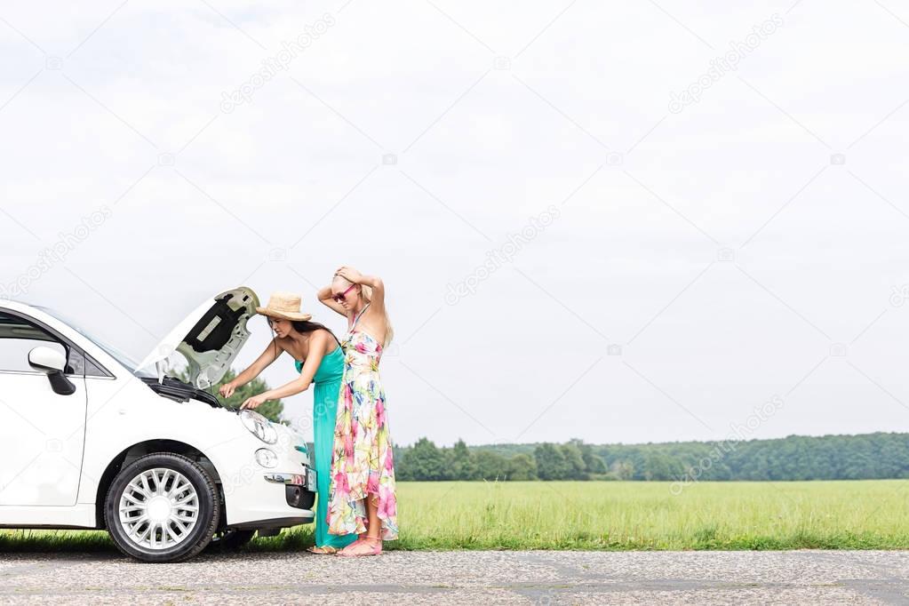 Female friends examining car 