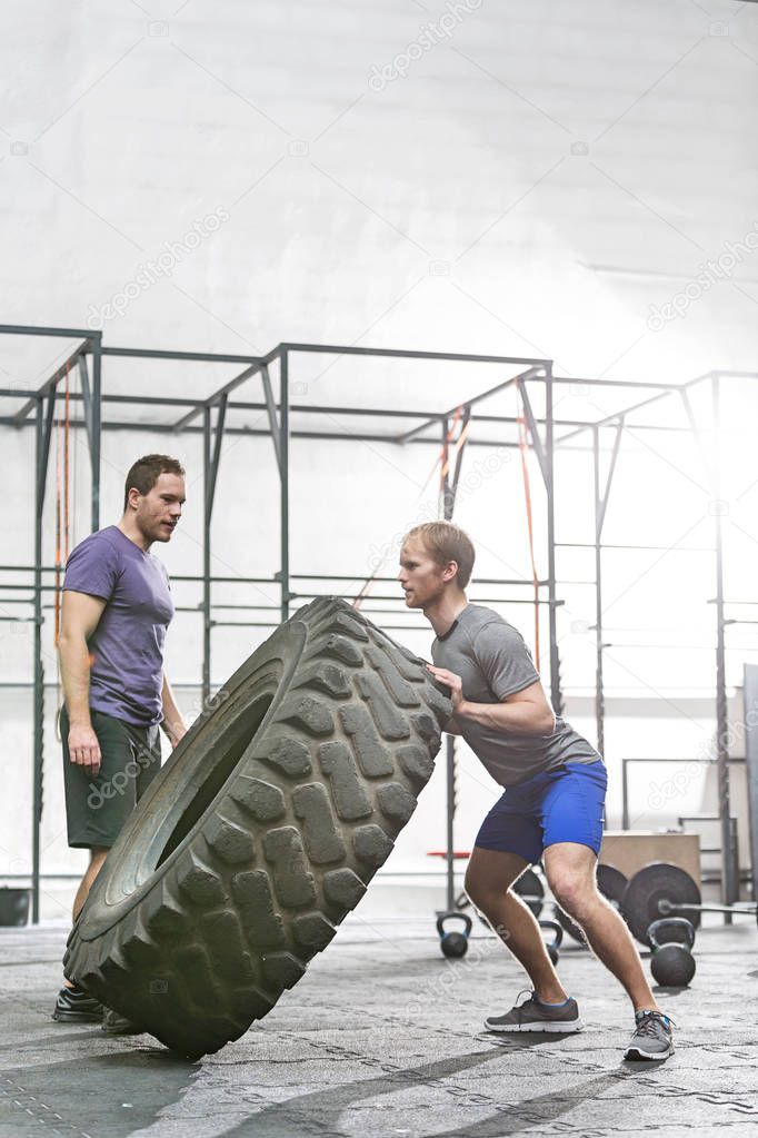 Man flipping tire in crossfit gym