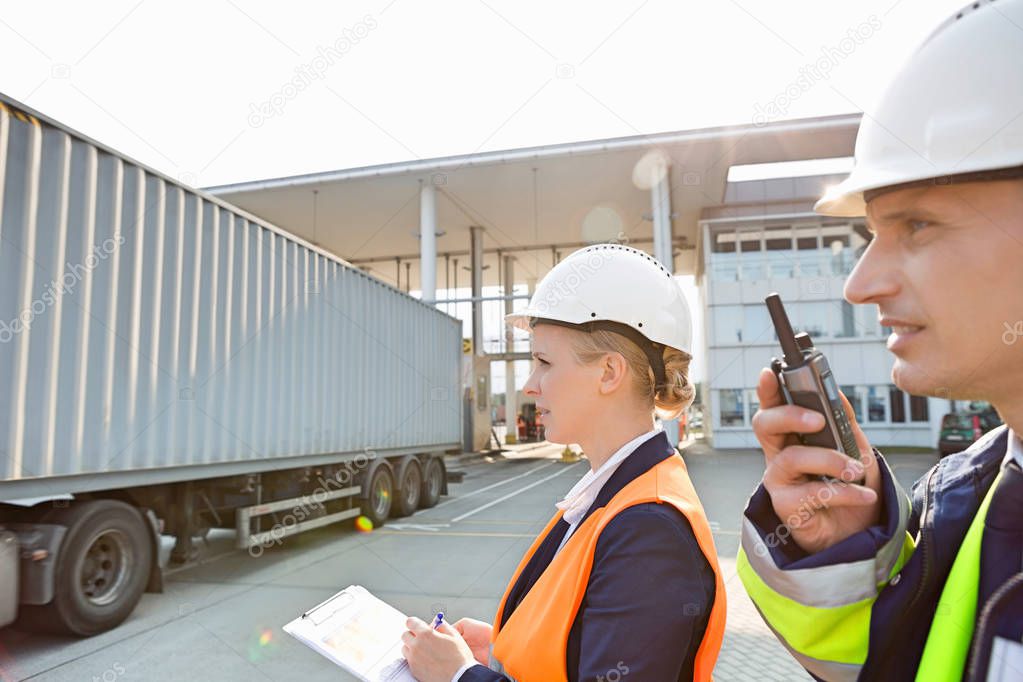 Male and female workers in shipping yard