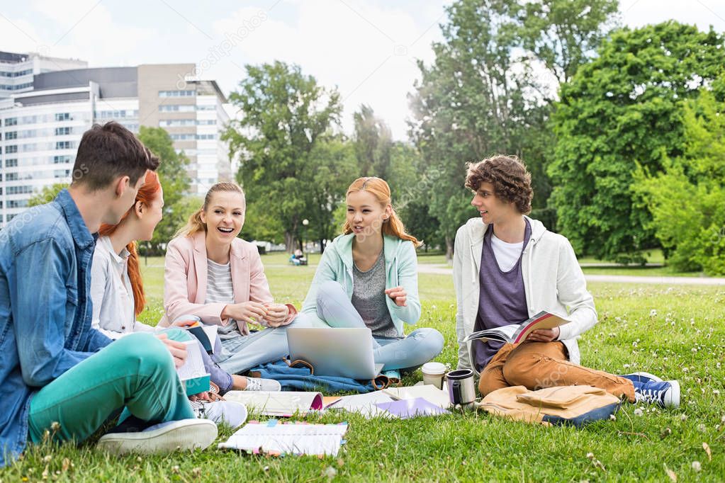 University friends studying on grass