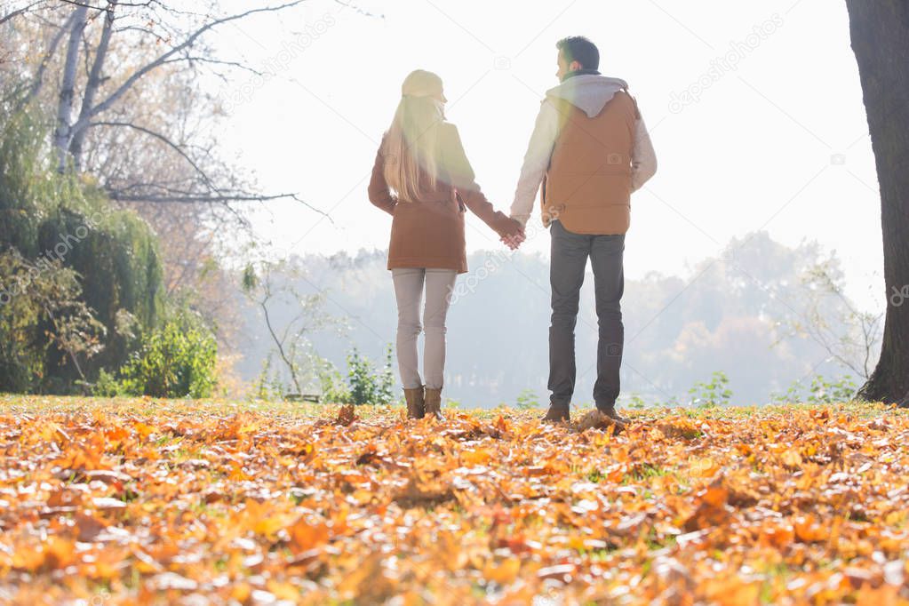 couple holding hands in park 