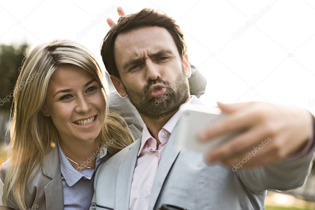 Playful business couple taking selfie