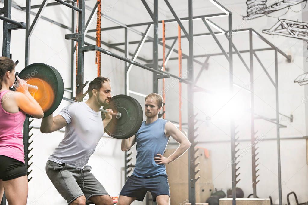 man in lifting barbell at crossfit gym
