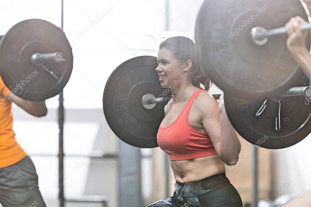 woman lifting barbell in crossfit gym