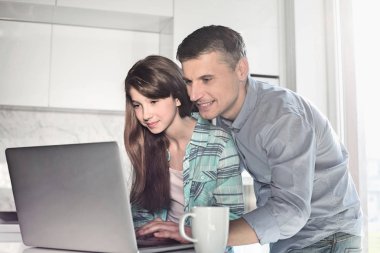 Father and daughter using laptop  clipart