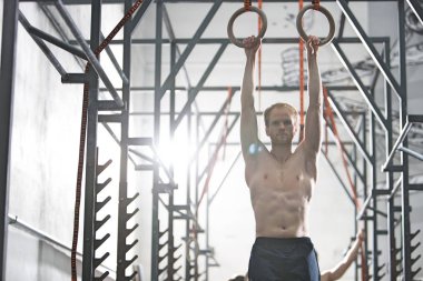 Kendine güvenen adam jimnastik yüzük ile egzersiz