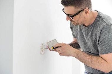 Elektrik prizine üzerinde çalışan adam