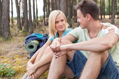 Hiking couple relaxing in forest clipart