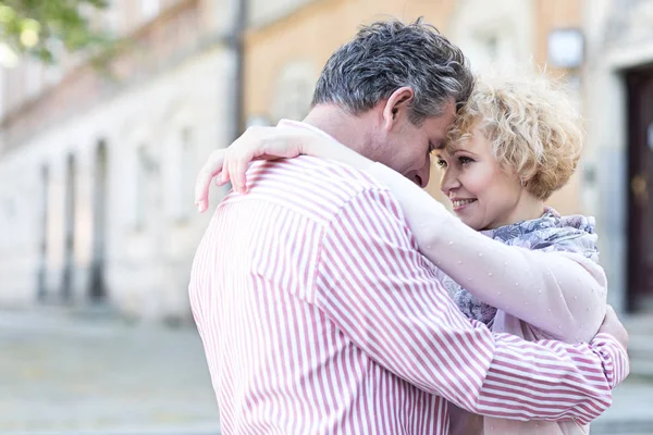 Middle-aged couple embracing in city — Stock Photo, Image