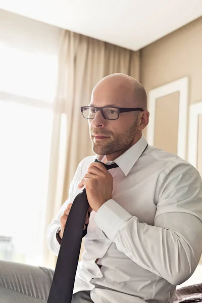 Businessman adjusting necktie — Stock Photo, Image