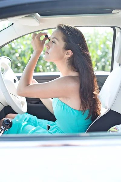 Mujer aplicando rímel en el coche — Foto de Stock