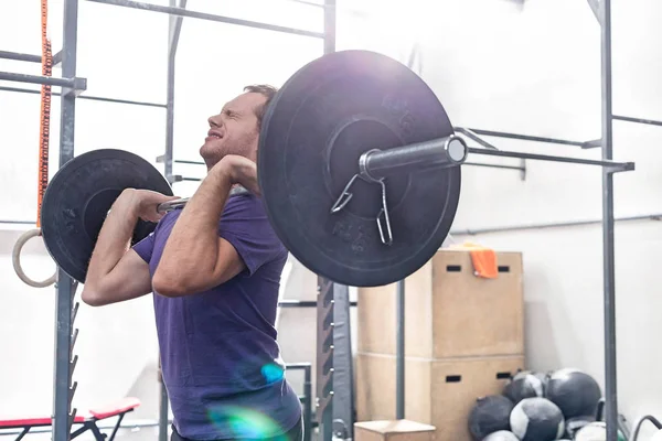 Confident man lifting barbell — Stock Photo, Image