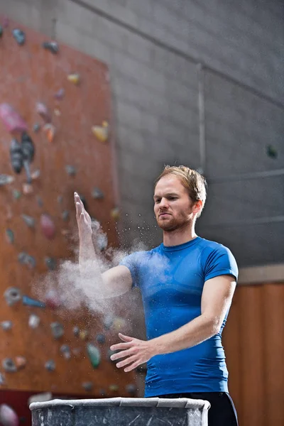 Man dusting powder by climbing wall — Stock Photo, Image