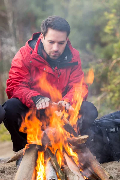 Wandelaar opwarming van de aarde zijn handen op het kampvuur — Stockfoto