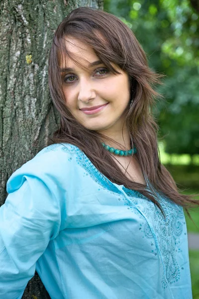 Femme debout près de l'arbre et souriant — Photo