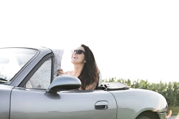 Mujer feliz sosteniendo mapa en convertible —  Fotos de Stock