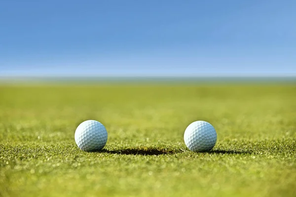 Bolas de golf cerca del agujero — Foto de Stock