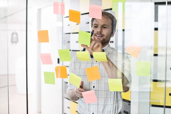 Hombre de negocios leyendo papel pegajoso — Foto de Stock